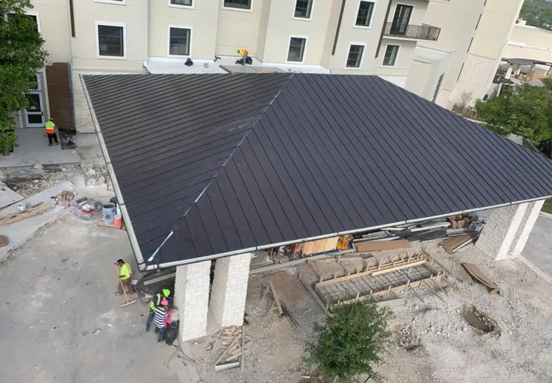 Metal roofing installation team working on a commercial building in Pikesville